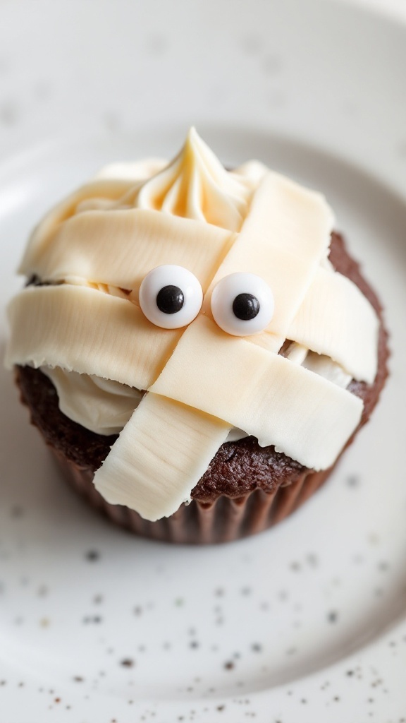 Mummy cupcakes decorated with frosting and candy eyes for Halloween.
